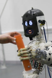  BERT2، إنسالي (روبوت) مساعِد بشري الشكل، يقدم شيئًا إلى إنسان حقيقي. حقوق الطبع: مختبر الإنساليات (الروبوتيات Robotics) لجامعة بريستول البريطانية. 